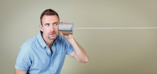 homem ouvindo telefone de lata - telephone can communication tin can phone - fotografias e filmes do acervo