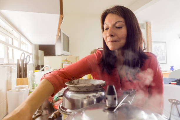 istock Mature woman at home preparing a meal 1255607827