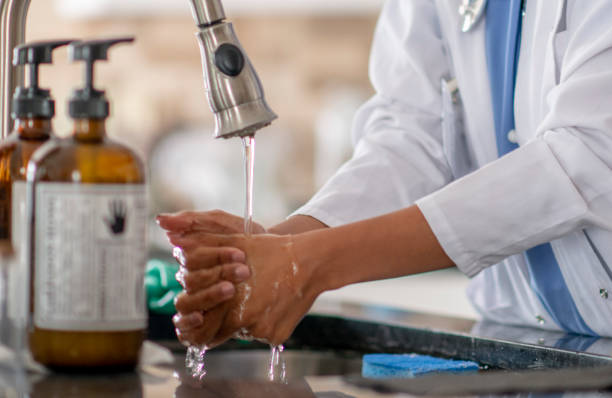 istock Female doctor washing hands 1255608916