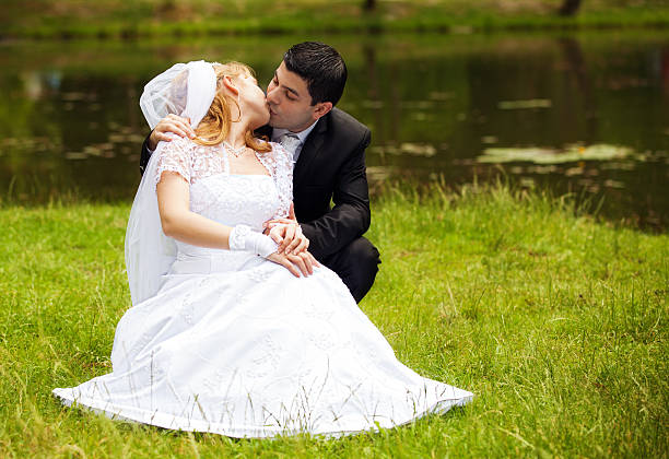 istock happy newlyweds on grass in park 125560910