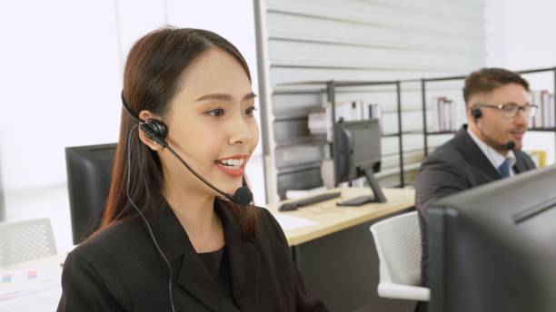 istock Business people wearing headset working in office 1255610694