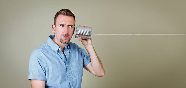istock Man listening to tin can telephone 125561084