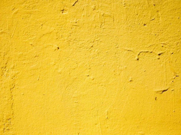istock Bright yellow painted concrete wall in natural daylight 1255613492