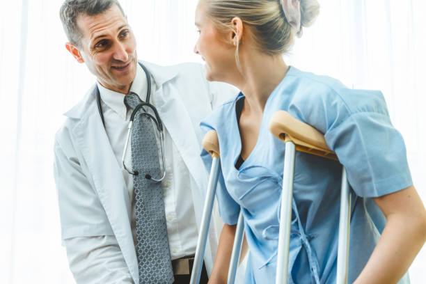 Doctor takes care of patient in crutch at hospital Doctor takes care of patient in crutch at hospital. Physical therapist and leg injury recovery concept. orthopedist stock pictures, royalty-free photos & images