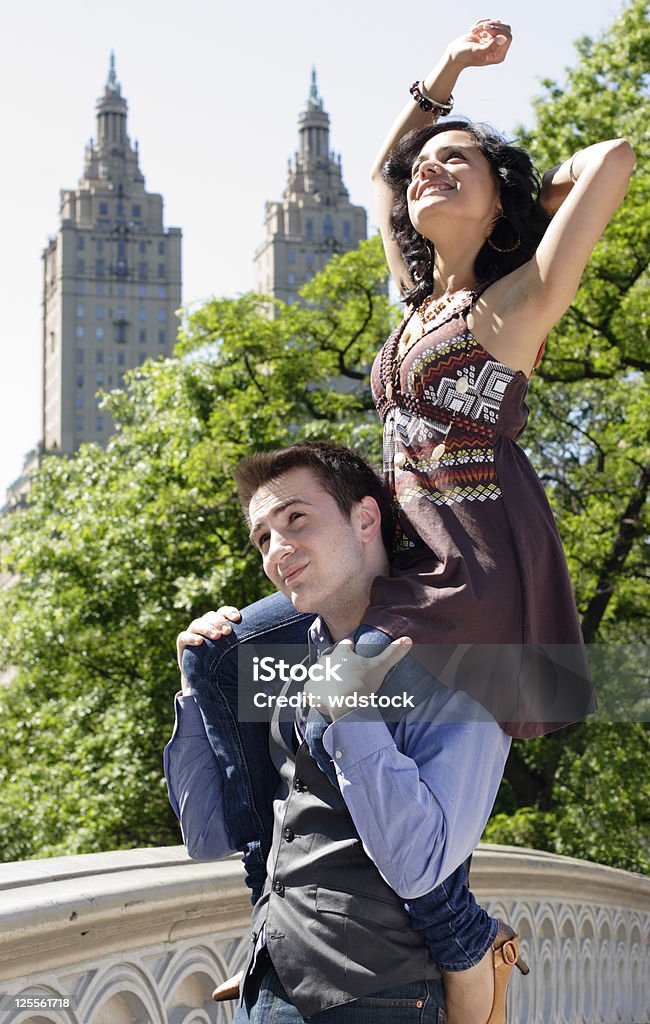 Mujer en el parque en un hombre de hombros - Foto de stock de Amistad libre de derechos