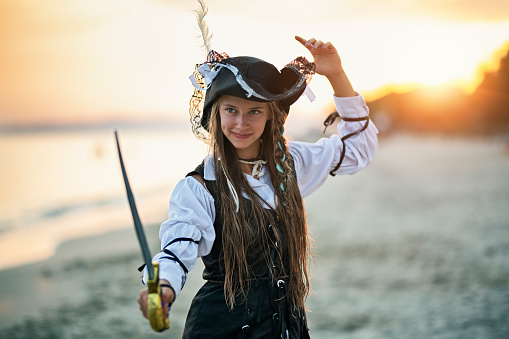 Happy, strong and confident pirate girl holding a sabre. \nNikon D850