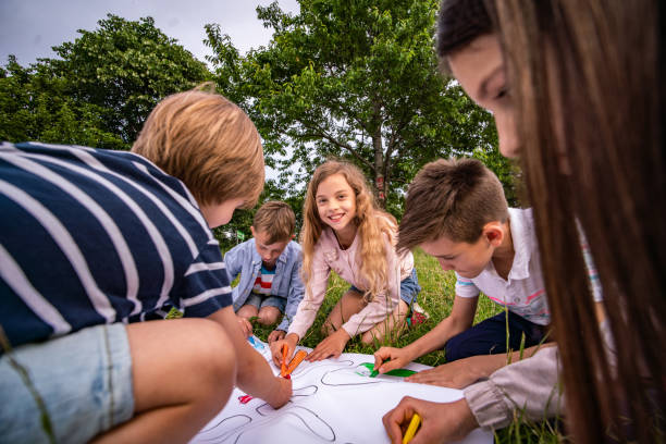 istock Group of children drawing in nature 1255619469