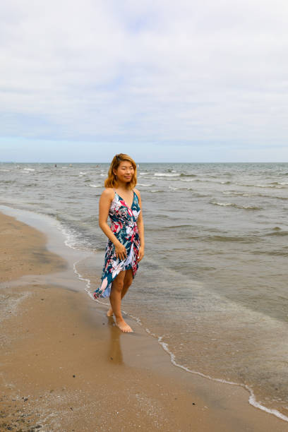 istock Barefoot young woman walking along lake shore 1255619554