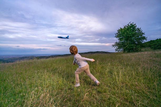Little boy is throwing the plane into the air