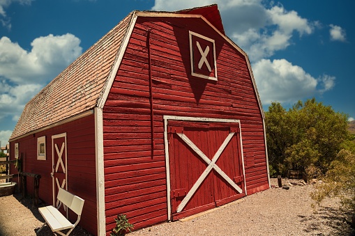 Las Vegas, Nevada - 06 15, 2020: This image shows a classic red barn in a rural, outdoor setting with a cloudscape behind.