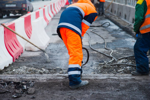 istock Road worker removes old asphalt with a jackhammer 1255620297