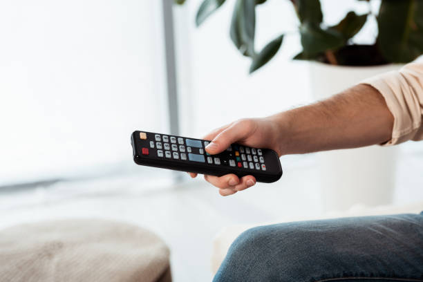istock Cropped view of man holding remote controller at home 1255620491