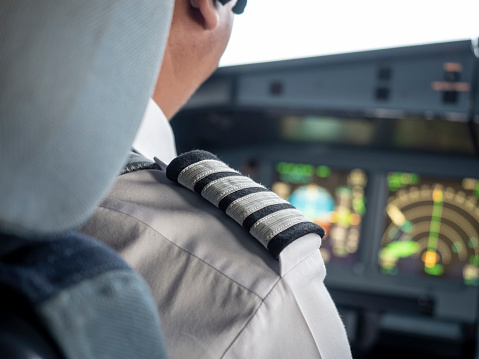 Handsome male pilot flying a private plane and wearing headset