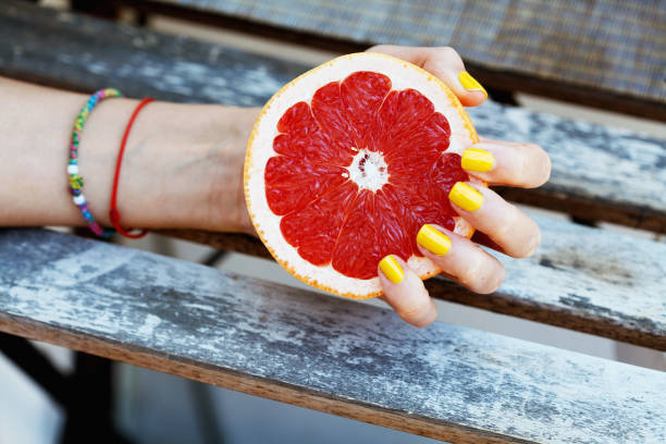 istock Woman holding a sliced grapefruit 1255622311