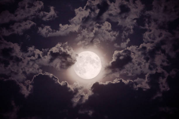 istock Full moon amid dark scenic clouds. 1255623336