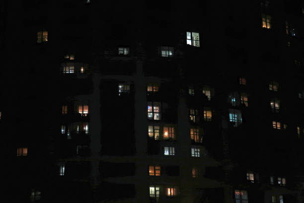 istock Apartment building with burning windows at night 1255628267