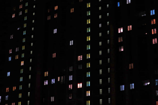 istock apartment building with burning windows at night 1255628275