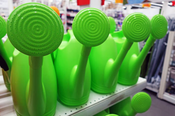 large green garden watering cans with a spray nozzle on a store shelf