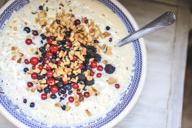 istock bowl with blue national pattern with cottage cheese and yogurt smoothie with chia, raspberries, red currants, blueberries, blackberries, walnuts on a white wooden table. Top view, close up 1255631411