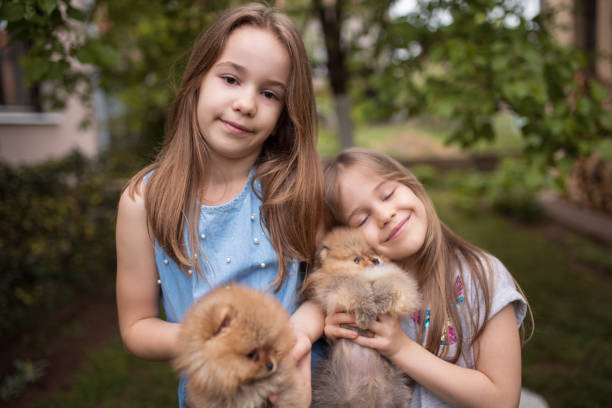 istock Sisters holding puppies in backyard 1255631424