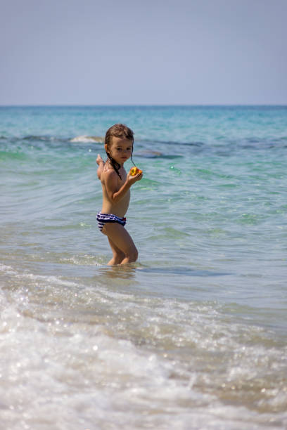 little girl eating a peach in the sea