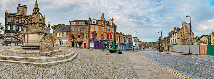 Linlithgow, Scotland, United Kingdom – June 16, 2020: Linlithgow Town Centre is in the heart of Linlithgow in West Lothian, boasting a cross well, shops and restaurants. Whilst typically bustling with locals and tourists, the town centre streets were empty during the coronavirus lockdown in spring 2020.