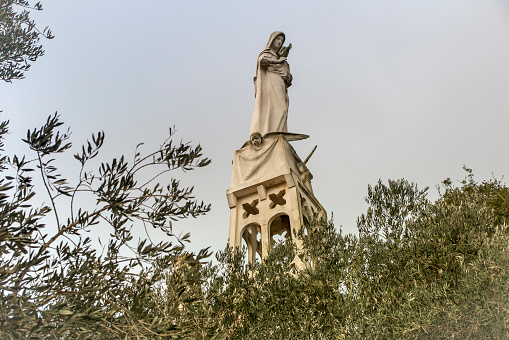 Abu Ghosh, Israel, January 29, 2020: Statue of the Mother of God with a baby in her arms on the roof of the Our Lady of the Ark of the Covenant Church in Abu Ghosh near Jerusalem in Israel