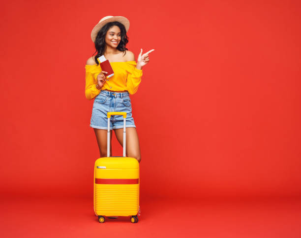 istock Ethnic tourist with luggage pointing away 1255635857