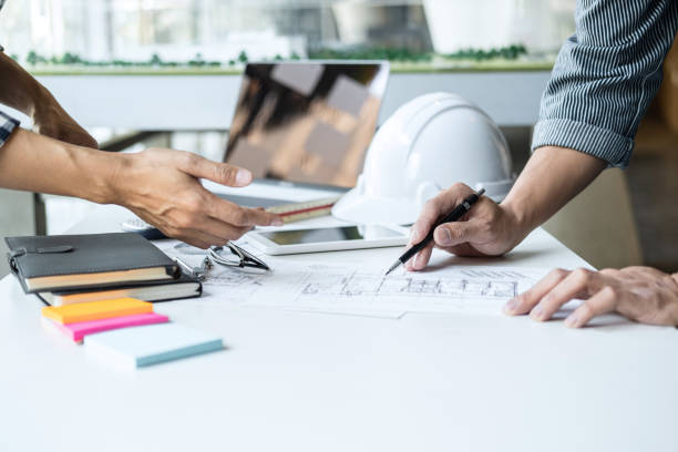 istock Construction and structure concept of Engineer or architect meeting for project working with partner and engineering tools on model building and blueprint in working site, contract for both companies 1255642546