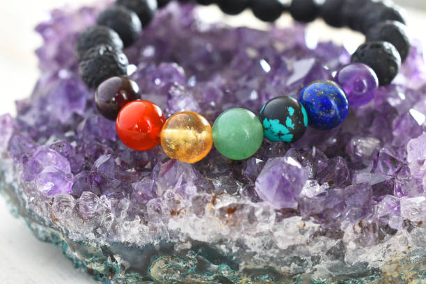 Chakra Bracelet Close Up A close up image of a beautiful chakra bracelet charging on a purple amethyst geode. bead photos stock pictures, royalty-free photos & images