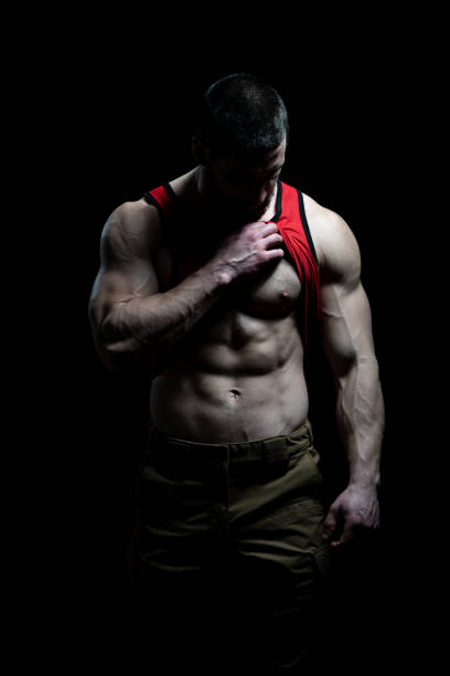 istock Muscular Man Flexing Muscles on Black Background 1255651035
