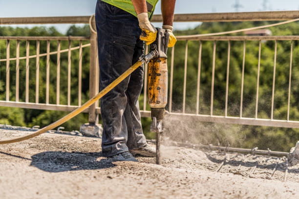 istock Close-up of manual worker using jackhammer and repairing bridge. 1255653866
