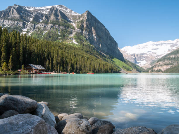 istock Turquoise glacier lake with boathouse surrounded by mountains 1255656998