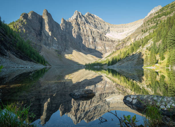 istock Beautiful alpine lake with still water surface reflecting its surroundings 1255657085