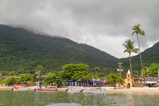 March 5, 2020 - Ilha Grande, Rio de Janeiro, Brazil: General landscape view of tropical paradise Ilha Grande's town village over cloudy day with some anchored tourist boats and yachts.\n\nIlha Grande (Big Island) is a coastline and a group of small islands and cays located at Rio de Janeiro State in Brazil. A very popular destination for leisure, diving, snorkeling, kite surfing and all kind of water activities. The beauty of the turquoise coastal beaches of Brazil are almost indistinguishable from those of the Bahamas, French Polynesia, Malau, Hawaii, Cancun, Costa Rica, Florida, Miami, Maldives, Cuba, Fiji, Bora Bora, Puerto Rico, Honduras, Thailand, Philippines, or other tropical vacation travel destinations.