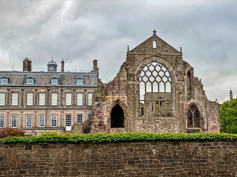 Edinburgh, Scotland, United Kingdom – May 19, 2020: Palace of Holyrood House, at the bottom of Edinburgh's Royal Mile, serves as both an official royal residence, as well as, a tourist attraction. The Holyrood Abbey is ruined cloister visible from Holyrood Park.