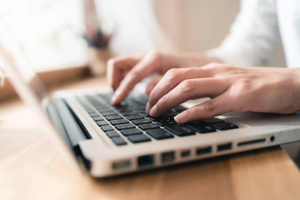 istock Close up hands of woman using laptop computer working and searching online information with blurry background. copy space of technology business and social distancing concept 1255667657