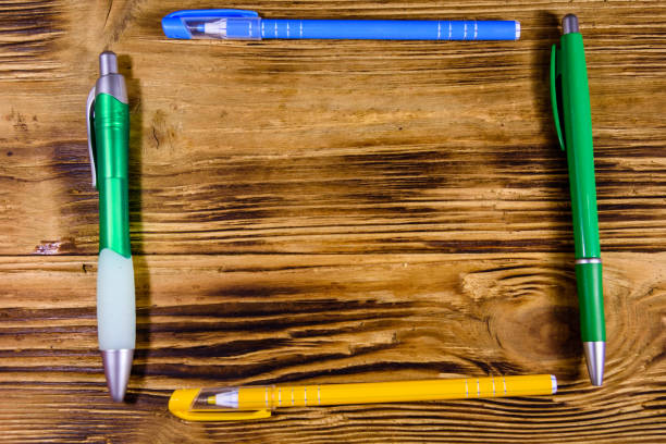 istock Multi colored ball pens on a wooden table. Top view 1255670501