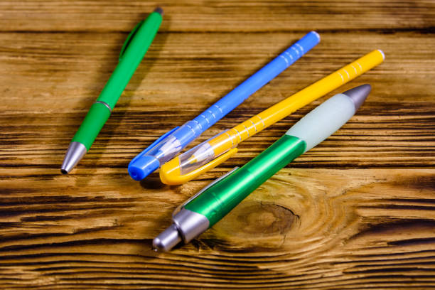 istock Multi colored ball pens on a wooden table 1255670502