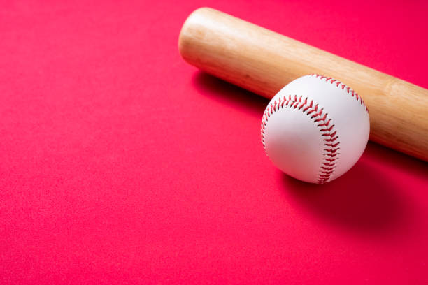 istock baseball and baseball bat on red table background, close up 1255670555