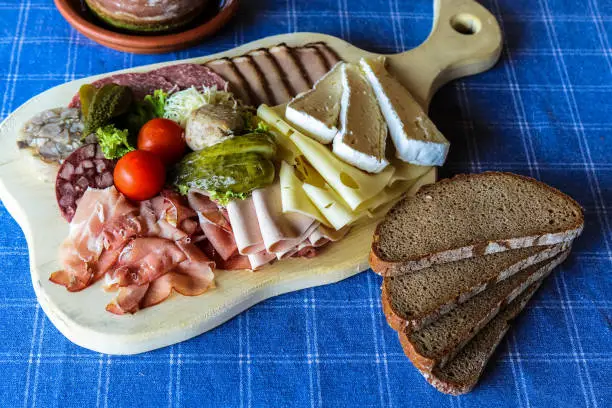 Kitchen board with traditional Bavarian food, sausage, cheese and farm bread