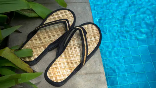 Swimming pool with fresh blue water and slippers on poolside