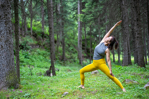 Young Asian woman practicing yoga in the forest