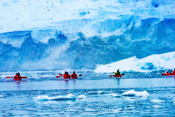 istock Snowing Red Kayaks Iceberg Blue Glacier Paradise Harbor Antarctica 1255676046