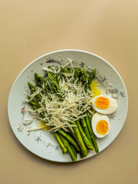Fresh cut green cooked asparagus with fried eggs