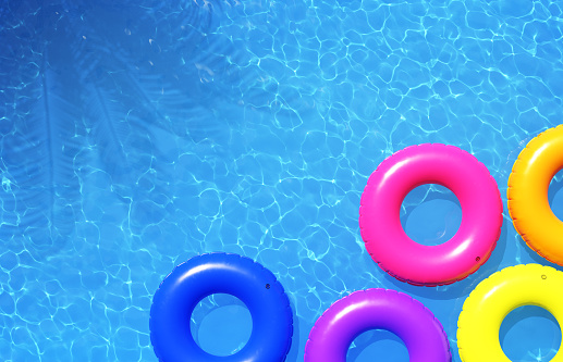 Colorful swimming rings in blue swimming pool. 3d illustration