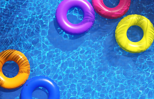 istock Multi-colored swimming rings in swimming pool. Pool party, summer background. Top view 1255683148
