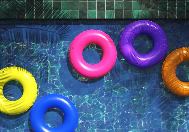 istock Multi-colored swimming rings in swimming pool. Pool party, summer background. Top view 1255683164