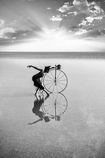 Ballerina dancing with old bicycle on the lake - Salt lake in Turkey