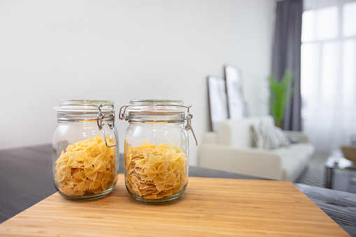 Jars of pasta on the background of the apartment.